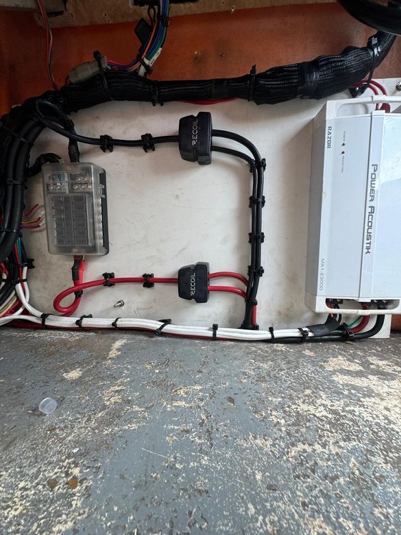 Marine amplifier and fuse block mounted under the console with loomed, strain-relieved cabling