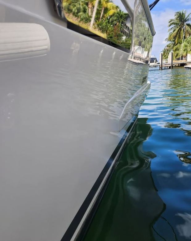 Hull side and waterline finished to a clean gloss at the dock