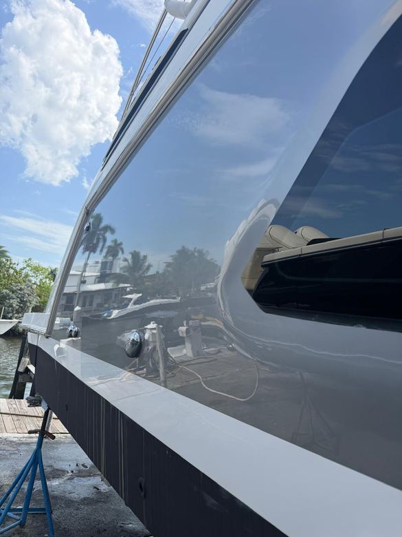 Dark yacht topsides after a full exterior detail and protective ceramic coating