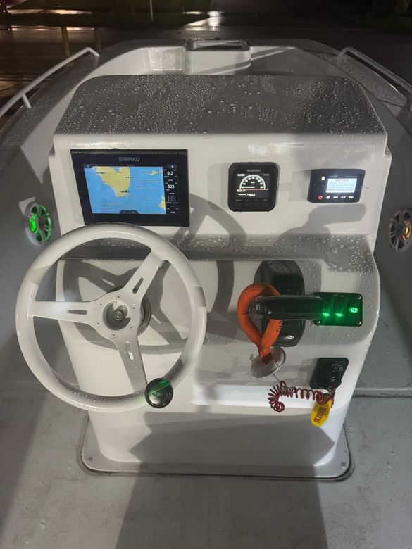 Night helm with a Simrad chartplotter, Fusion stereo and green LED-lit speakers