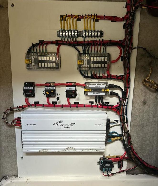 Complete rewire on a backing board with dual fuse blocks, labeled breakers, bus bars and an amplifier